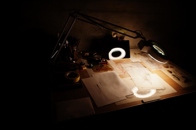 Desk with turn on lamp and painting items