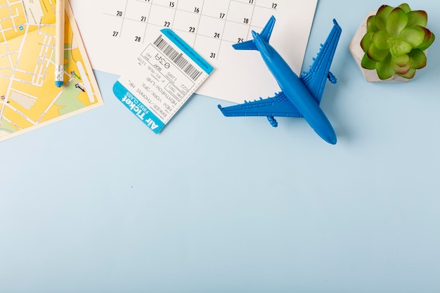 Desktop with a map coffee and an airplane on a blue background Travel concept