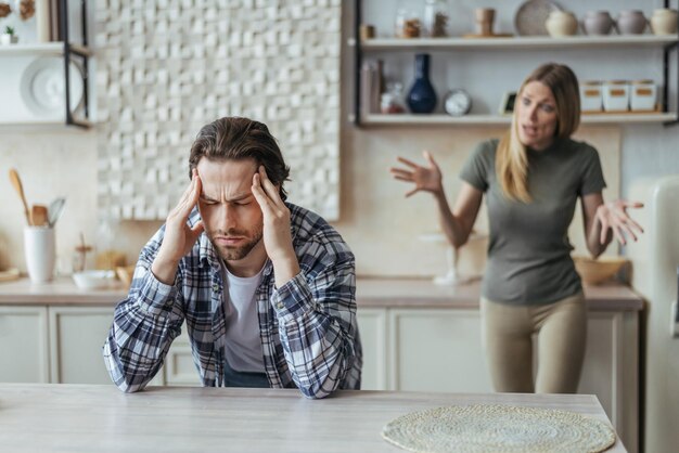 Despaired offended millennial european man with stubble hold his head with hands ignoring screaming