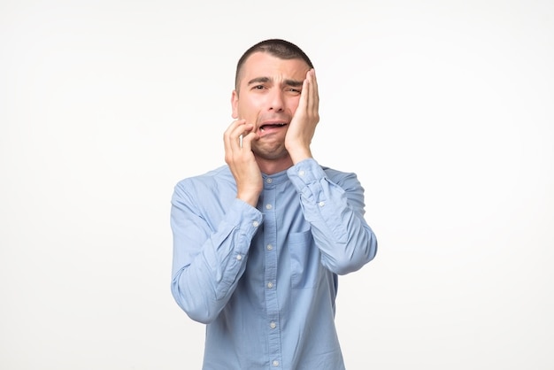 Despaired spanish man in blue shirt is crying