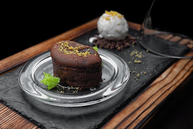 Dessert Chocolate Fondant with ice cream on a glass plate on a wooden board selective focus