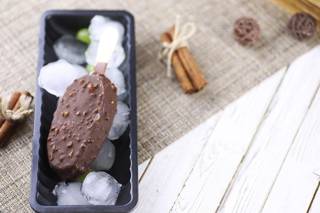 Dessert chocolate ice cream with nuts on a wooden stick