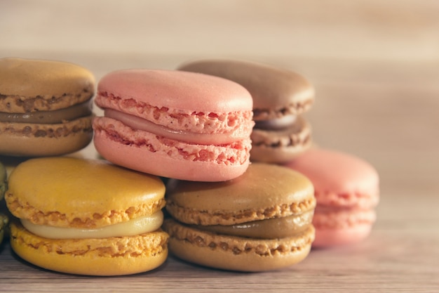 Dessert of French macarons in pastel colors on wood. Copy space. Selective focus.