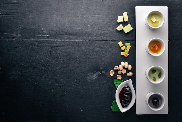 Dessert Pistachios dried fruits cherries and chocolate Top view Free space for text On a wooden background