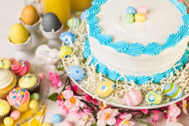 Dessert table set with cake and cupcakes for Easter brunch.