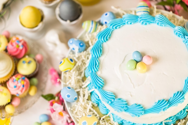 Dessert table set with cake and cupcakes for Easter brunch.