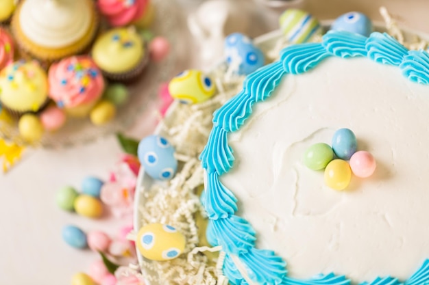 Dessert table set with cake and cupcakes for Easter brunch.