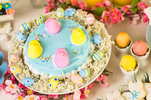 Dessert table with Easter cake decorated with traditional Easter marshmallow chicks.