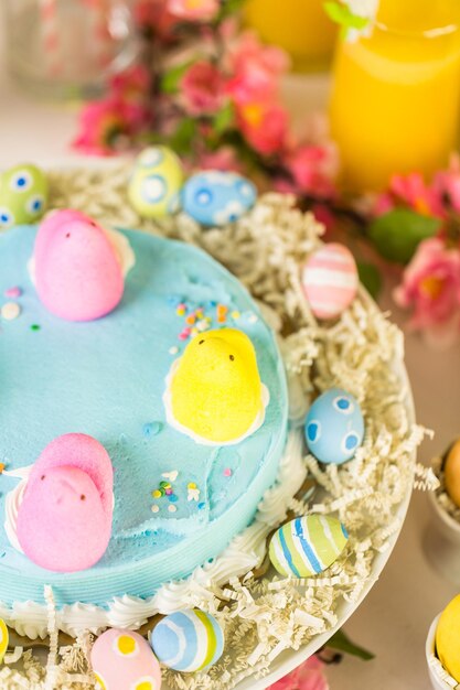 Dessert table with Easter cake decorated with traditional Easter marshmallow chicks.