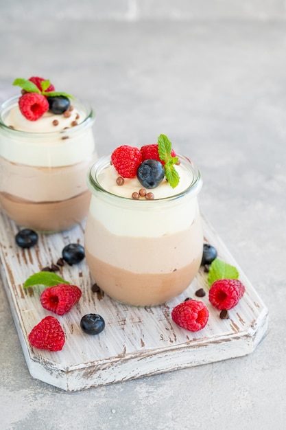 Dessert three chocolate in a glass jar with fresh blueberries raspberries and blackberries on top