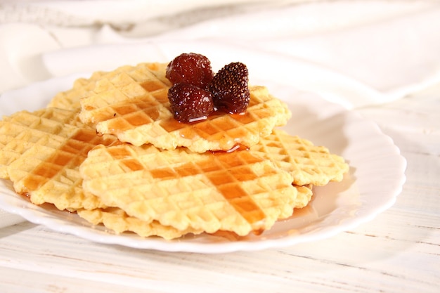 Dessert of waffle cookies and strawberry jam lies on a plate