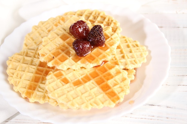 Dessert of waffle cookies and strawberry jam lies on a plate