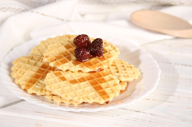 Dessert of waffle cookies and strawberry jam lies on a plate