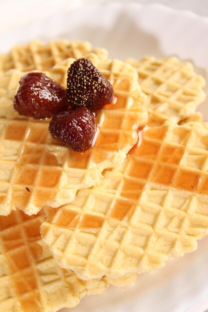 Dessert of waffle cookies and strawberry jam lies on a plate