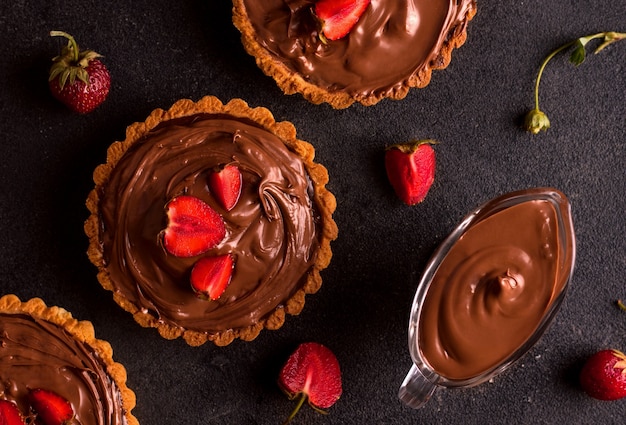 Dessert with peanut butter. Chocolate tart with strawberries on a dark background