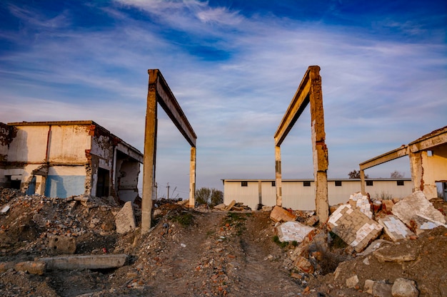 Destroyed abandoned industrial buildings of a former factory. The remains of concrete structures, destroyed brick walls.