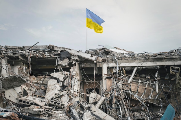 Destroyed building view of the ruins wreckage of the building and the Ukrainian flag