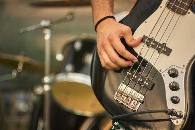 Detail of a bass player who plays his eacoustica bass at a live rock music concert.