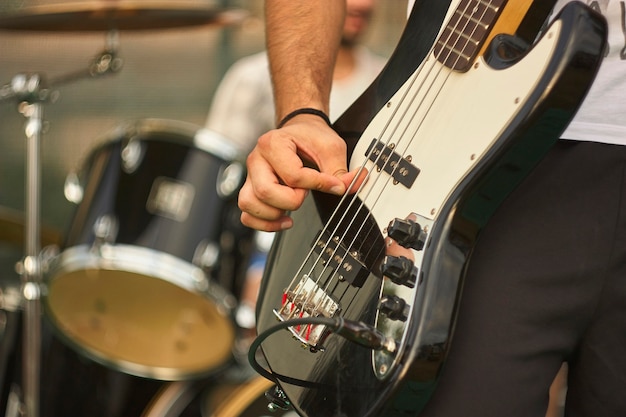 Detail of a bass player who plays his eacoustica bass at a live rock music concert.