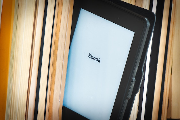 Detail of an ebook reader among classic books