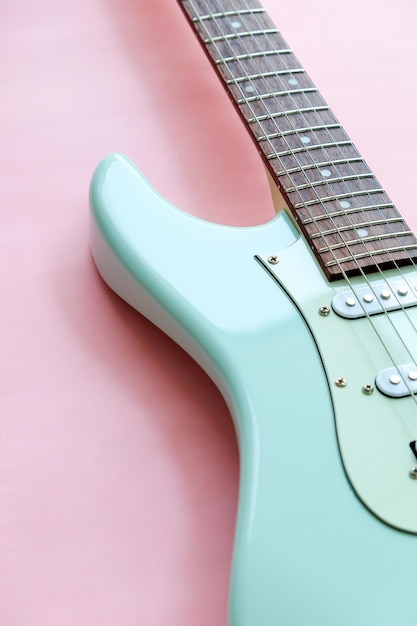 Detail of electric guitar on a pink surface