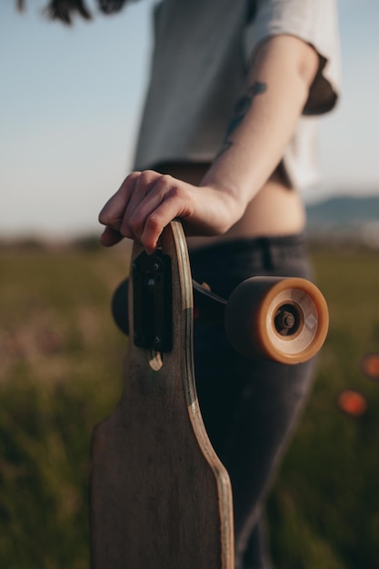 Detail of a girl leaning on a longboard anonymous photography faceless sunny day high quality photo