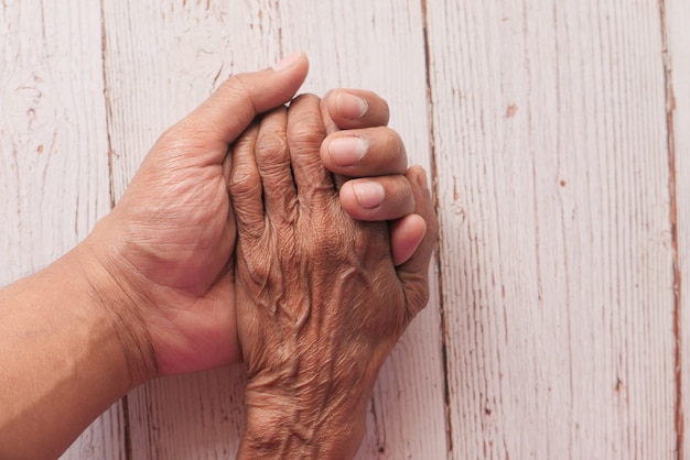 detail of man's hand hand holding senior women's hand