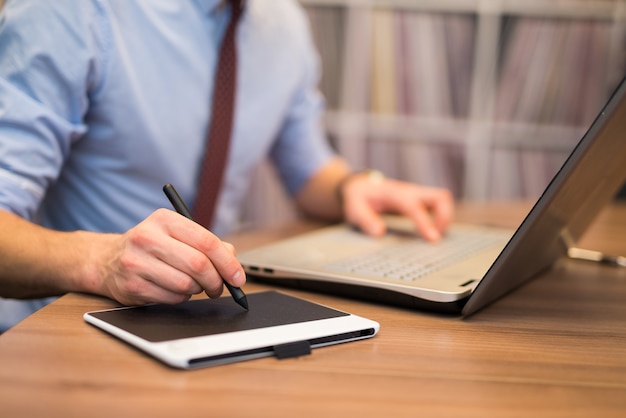 Detail of a man using a tablet pen