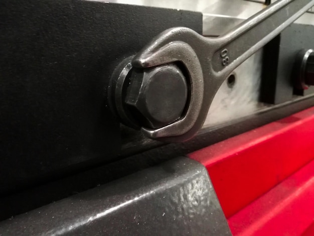 Detail of a mechanic's hand with a spanner opening a screw to fix a machine