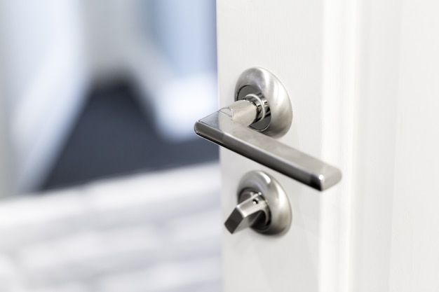 Detail of a metallic knob on white door