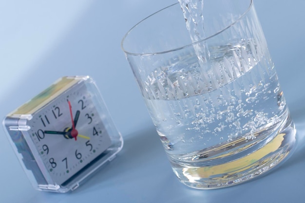 Detail of person filling glass of water hydration concept