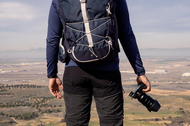 Detail of an unrecognizable photographer holding the camera with his hand in the foreground