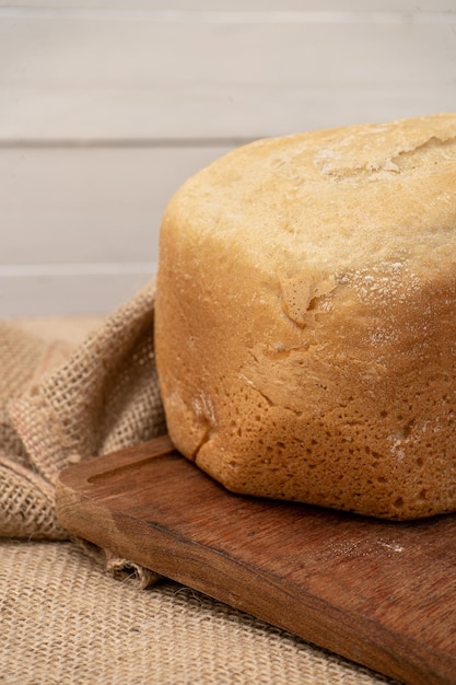 Detail view of bread made with a home bread machine on a wooden table Vertical orientation