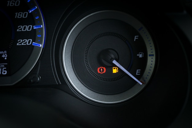 Detail with the fuel gauges showing and empty tank on dashboard of car