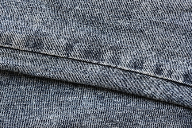 Detailed abstract texture of dark blue denim cloth Background image of old used denim trousers fabric