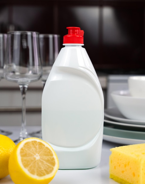 Detergent lemon sponge and clean dishes on the table in the kitchen Cleaning service concept