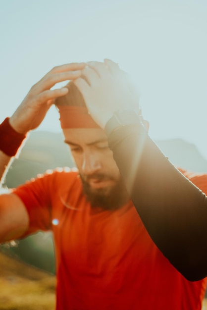 A determined athlete preparing for the start of training on the top of the mountain at sunrise