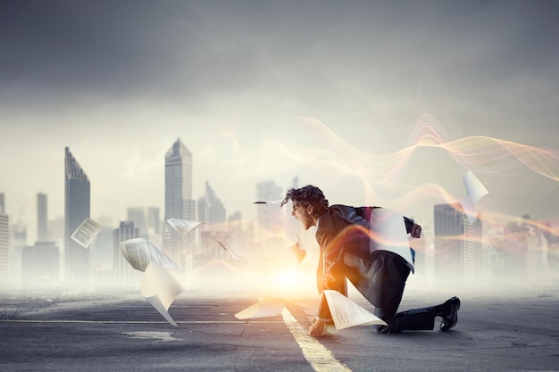 Determined businessman leaving fire trails on asphalt. Mixed media