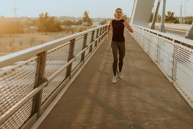 Photo determined runner jogs along a sunlit bridge during the golden hour blending fitness and serenity in an urban landscape