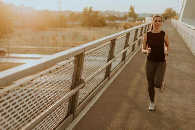 Photo determined runner jogs along a sunlit bridge during the golden hour blending fitness and serenity in an urban landscape