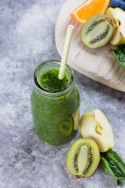 Detox Clean Eating Vegan Drink Concept. Fresh Green smoothies with fruits on table background