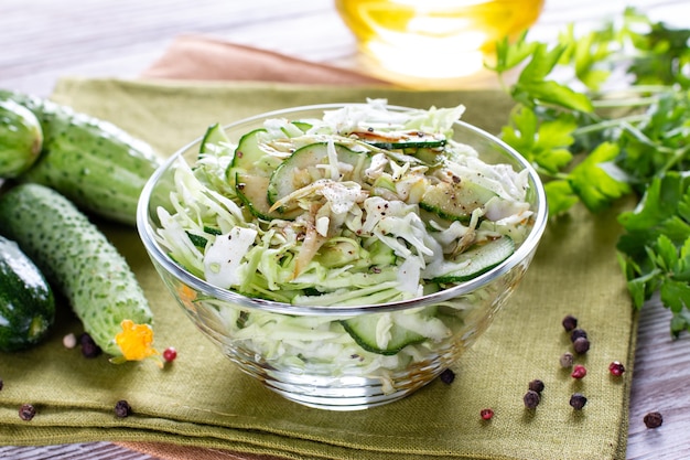 Detox spring salad from green vegetables (cabbage, cucumber, green onion and parsley) on a plate.