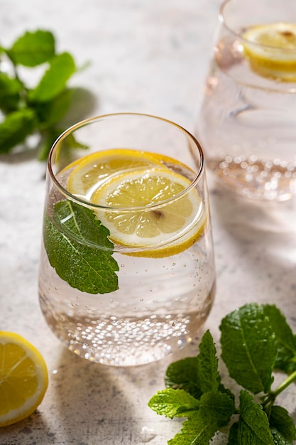 Detox water infused refreshing drink with lemon blueberry and mint Bright background Pink glasses