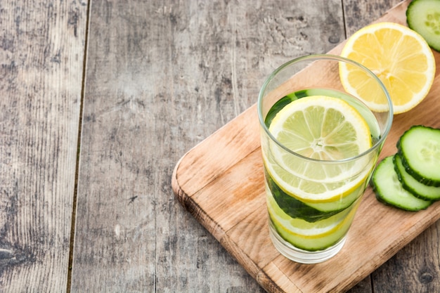 Detox water with cucumber and lemon on wooden table