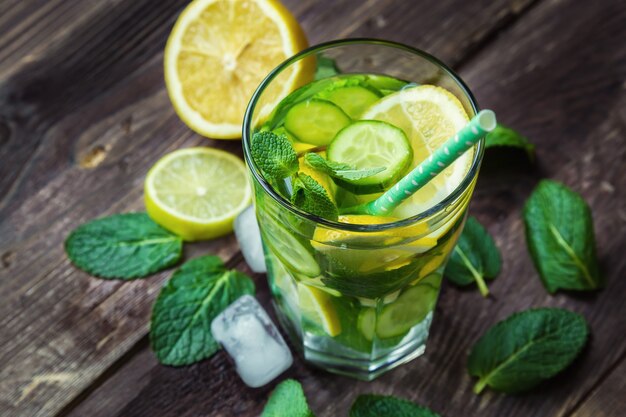 Detox water with lemon, cucumber and mint on rustic wooden table. Top view.