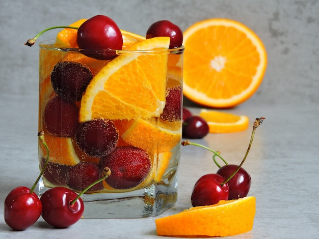 Detox water with orange and cherries.