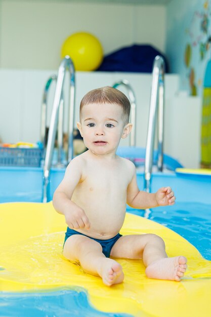 Development for babies A little boy is learning to swim in the pool Children's first swimming lessons Development for babies