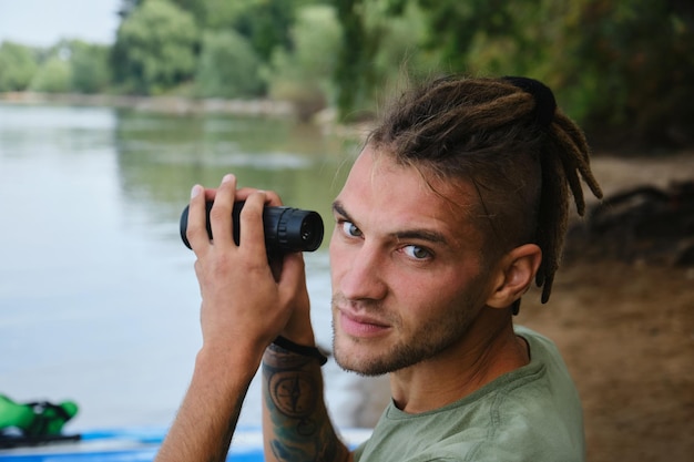 Device for observing nature and surrounding world Male tourist looks around using monocle