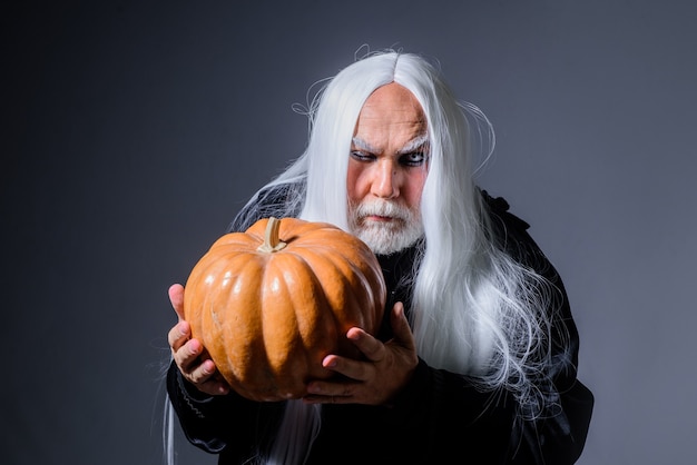 Devil vampire man with orange pumpkin handsome demon with jack o lantern happy halloween evil wizard