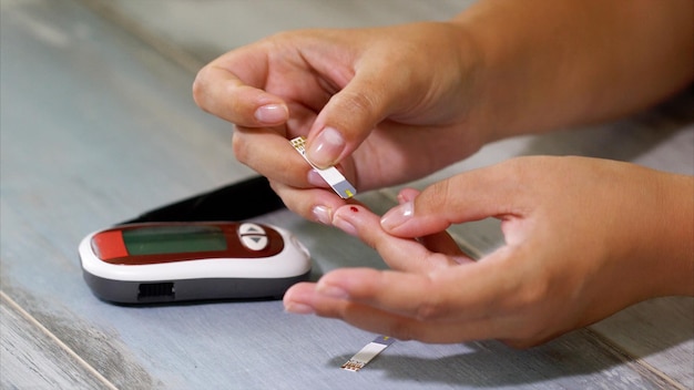 Photo diabetes blood glucose meter adult man measuring sugar level in blood at the table